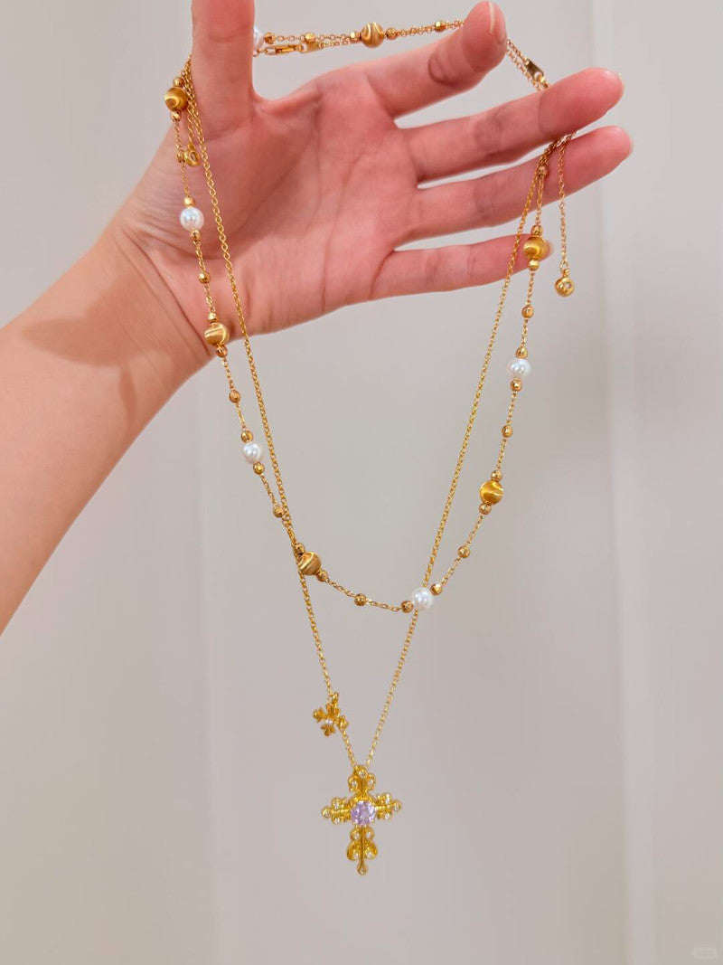 aphroseprome gothic vintage cross necklace flatlay, gold filigree with purple amethyst gem.